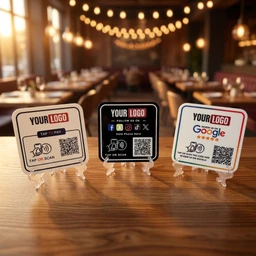 - What the product is: A set of three small square payment QR card signs/table top stands, each labeled for “YOUR LOGO” with a QR code and “Tap to Pay” or scanning instructions.
- Apparent audience: Unisex (the items are generic POS/payment signs suitable for any restaurant or cafe setting).
- Notable attributes: Material appears to be lightweight plastic or acrylic; colors shown include white, black, and white with colored logo accents; design is a tabletop display with a small stand and legible QR code layout, intended for contactless payment or Google/online logins.