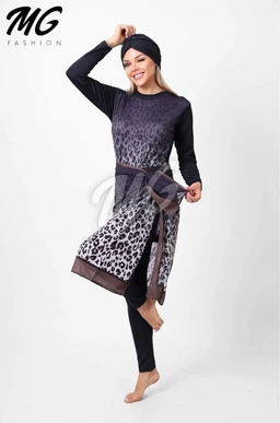 - This is a modest swimsuit/cover-up style garment (burkini) shown on a standing female model in a full-length view.
- Intended audience appears to be women (unisex interpretation not applicable here); the outfit features a long-sleeve top and a matching tunic over leggings, with a leopard-to-dark gradient pattern and a wrap belt at the waist.
- Notable attributes: dark navy to black base with a leopard print gradient from the midsection to the hem, a knee- to mid-thigh-length tunic overlay with a slit detail, paired with black leggings, and a headscarf or hair cover as part of styling. Material appears to be a stretchy, swimwear-appropriate fabric suitable for modest swimwear.