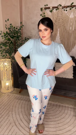 - What it is: A light blue short-sleeve pajama top paired with matching light-colored pants featuring blue floral embroidery, presented on a female model.
- Apparent audience: Women (based on fit, styling, and model).
- Notable attributes: Soft cotton-like fabric in pastel blue; short-sleeve relaxed tee with a round neckline; pale cream/white pants with blue floral embroidery; casual, comfortable loungewear style. No brand markings visible.