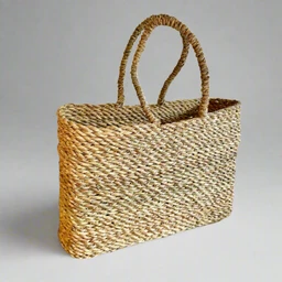 This is a rectangular woven tote bag made from natural straw or rattan fibers, featuring a tight, textured braid and two sturdy braided handles. The design is unisex in appearance, suitable for casual or beach-style use, with a roomy, open-top interior. Notable attributes include the natural beige-brown color, square-edged silhouette, and handwoven, artisanal style.